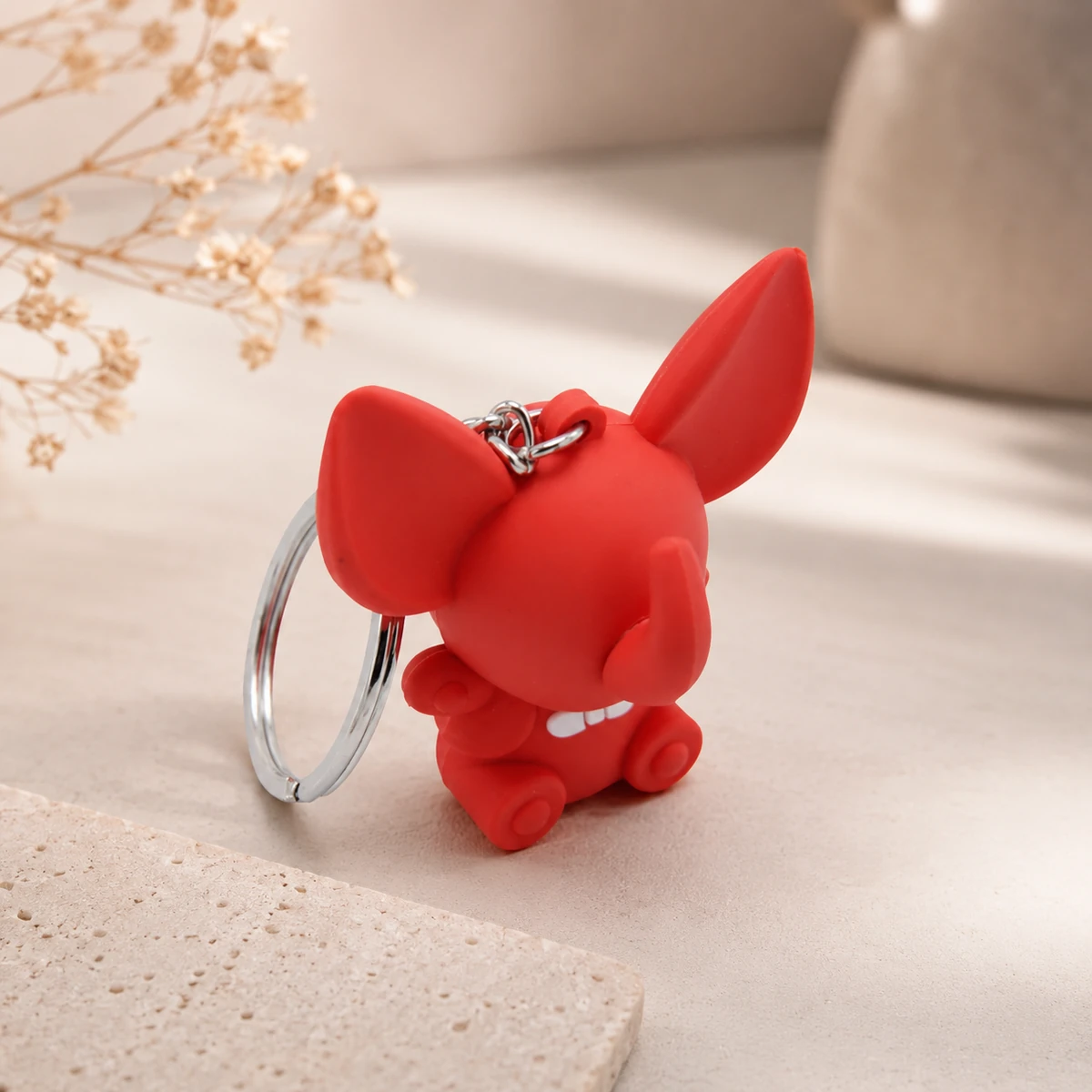 Porte-clés figurine en silicone rouge sur ensemble de bureau neutre